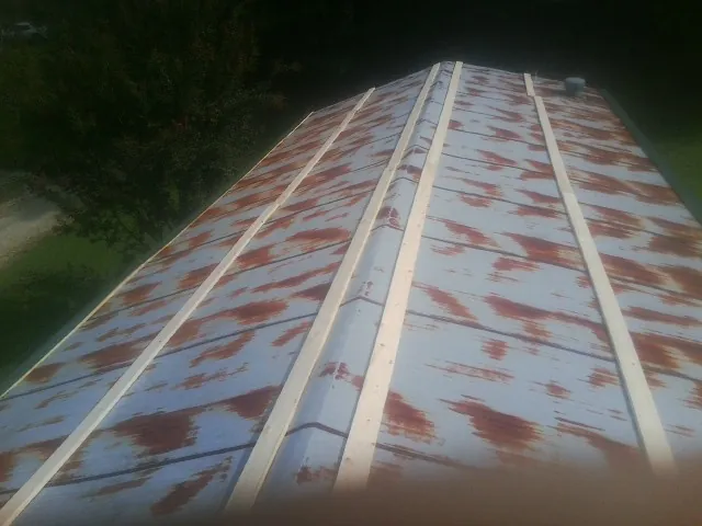 Rusted metal roof panels with new wood purlins before replacement — Storm Damage Roof Repair in Otoe by Roofing Brothers